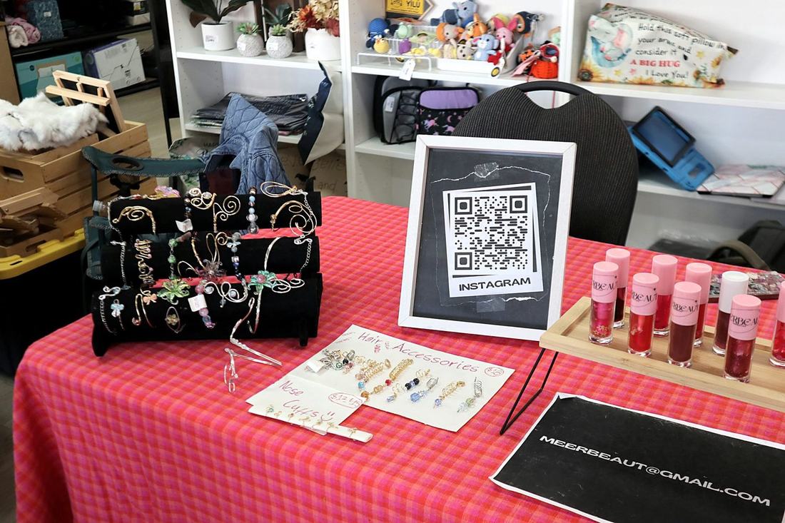 The MEERBEAUT market table with lip glosses, wire jewellery and an Instagram QR code