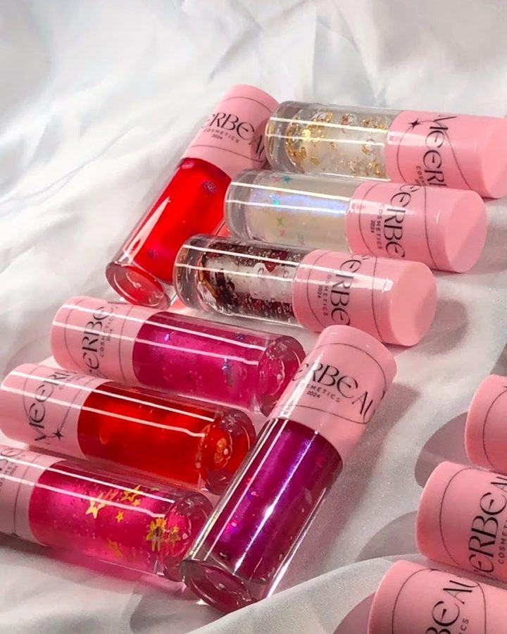 Glosses with petals and glitter laid out on white fabric