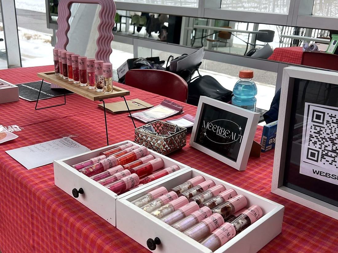 The MEERBEAUT market table with glosses in white drawers, a mirror and a QR code