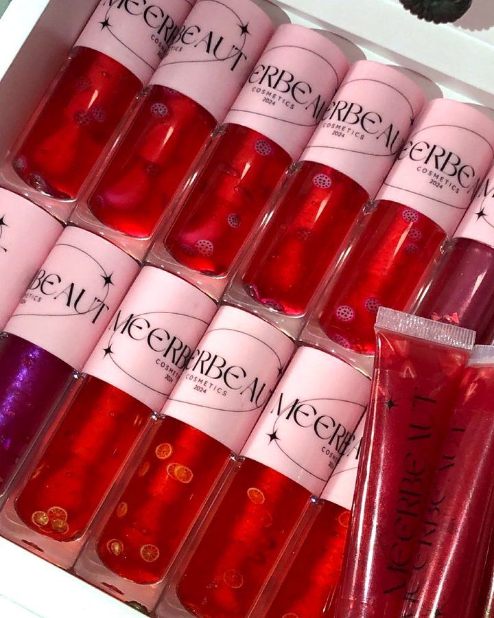 A white tray of red MEERBEAUT glosses with pink caps