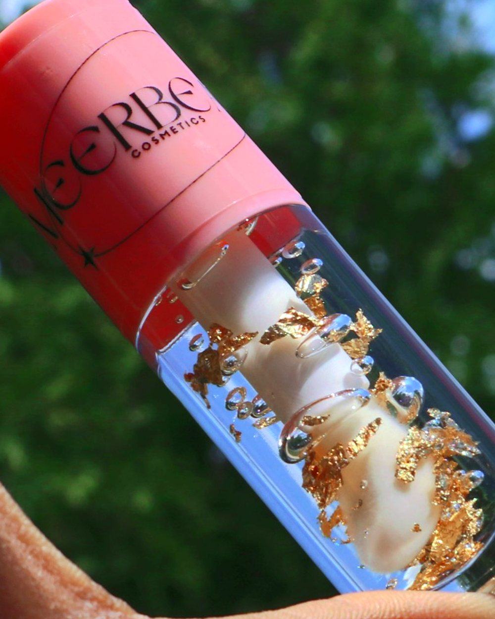 Gold Vanilla, a clear gloss with gold flakes, held up to the light