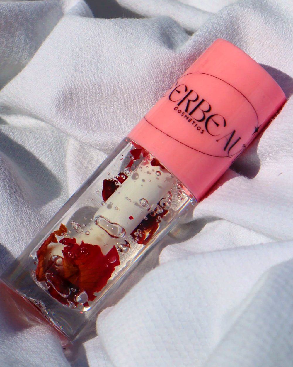 Minimal Rose, a clear gloss with rose petals, in a pink-capped MEERBEAUT wand tube