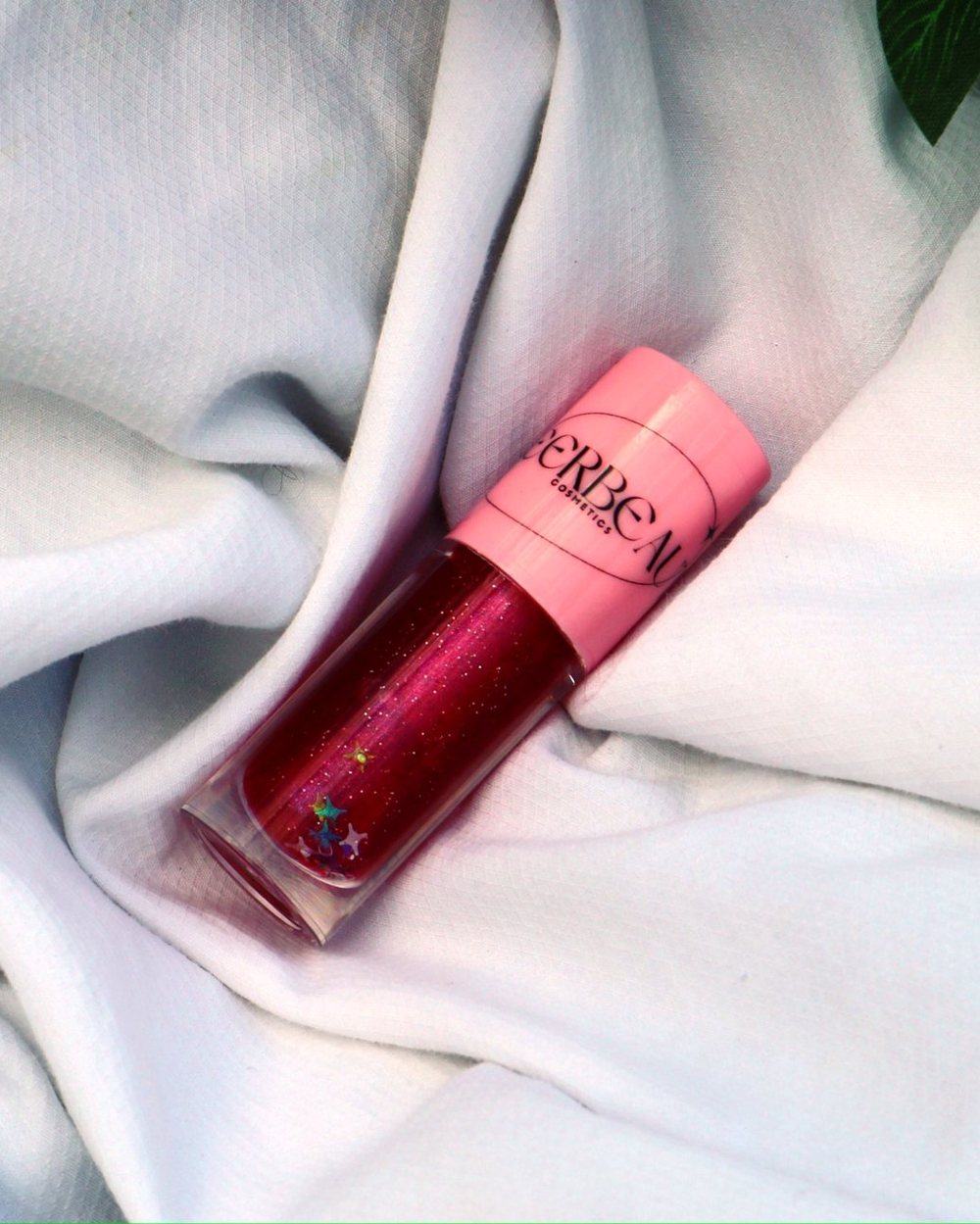 Starlight, a glitter gloss in a pink-capped MEERBEAUT wand tube on white fabric