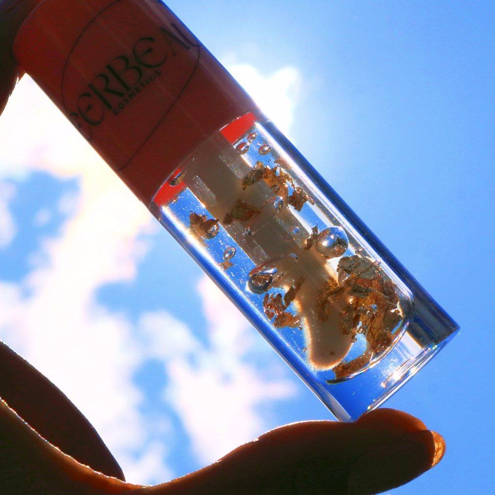Gold Vanilla, a clear gloss with gold flakes, held up to the sun