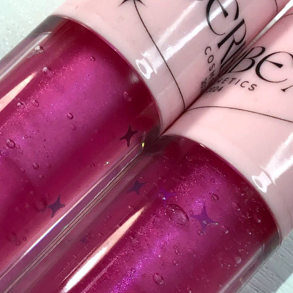 Pixie Dust, a magenta shimmer gloss with star flecks and tiny bubbles, close up