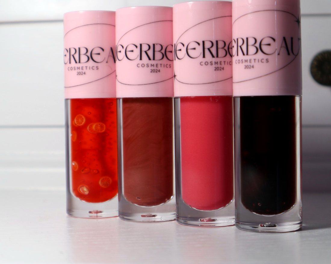Four MEERBEAUT glosses side by side in orange, brown, coral pink and deep berry